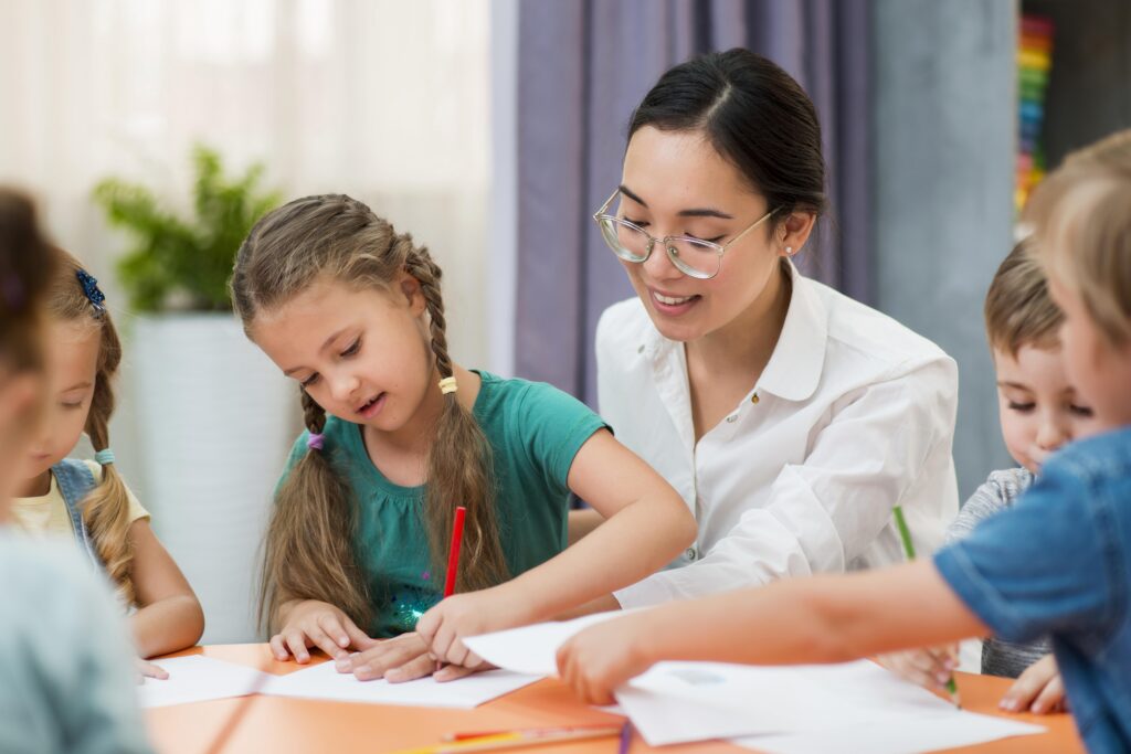 young teacher helping her students class